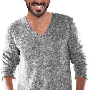 May include: A gray V-neck sweater with long sleeves. The sweater has a textured knit pattern and a relaxed fit. The neckline is a deep V-shape.