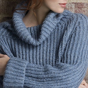 Könnte beinhalten: Ein blauer Strickpullover mit einem Rollkragen und gerippter Struktur.