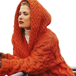 Peut inclure: Un cardigan à capuche orange avec un motif en tricot torsadé. Le fil épais et texturé crée un vêtement chaud et confortable. La capuche est grande et les manches sont longues. Un col roulé blanc est visible en dessous.