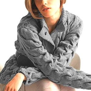 Puede incluir: Un cárdigan gris de punto de cable con una abertura larga en la parte delantera y mangas largas. El cárdigan está hecho de un hilo suave y grueso y tiene un ajuste holgado.