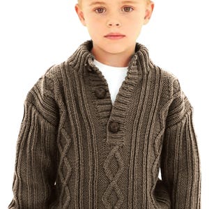 May include: A brown cable knit sweater with a v-neck and button closure. The sweater has a ribbed texture and a collar.