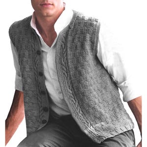 May include: A gray knitted vest with a button-up front and a cable knit design along the edges. The vest is worn over a white collared shirt. The vest has a textured pattern and a classic, timeless style.