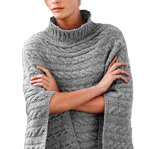 May include: A gray cable-knit sweater with a high, ribbed turtleneck. The sweater features a textured pattern and long sleeves. The person's arms are crossed. The sweater is made of a soft, warm material, perfect for cold weather.