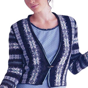 May include: A blue and white patterned cardigan with a V-neck and a single wooden button closure. The cardigan features a textured knit design with vertical stripes and a contrasting trim. The garment is worn over a light blue top.