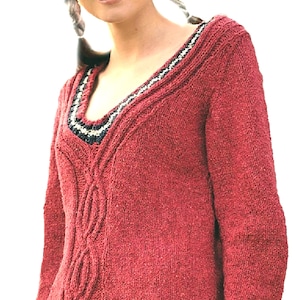 May include: A long-sleeved, deep red knitted sweater featuring a V-neckline with a decorative black and white patterned trim. The front of the garment displays a vertical cable knit texture running down the center, crafted from a textured yarn.