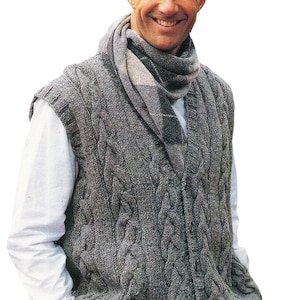 Puede incluir: Un chaleco gris de punto trenzado con una bufanda a juego. El chaleco tiene una parte delantera abotonada y un patrón texturizado. La bufanda está drapeada alrededor del cuello. Se lleva una camisa blanca debajo.