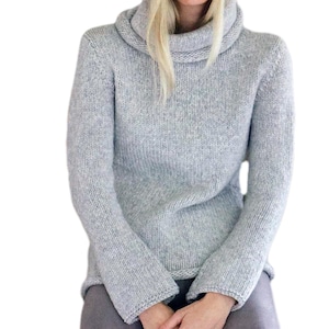 May include: A light grey turtleneck sweater with a ribbed knit texture.