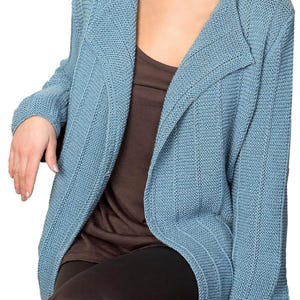 May include: A light blue cardigan with a long, open front and a ribbed texture. The cardigan is made of a soft, comfortable material and has a relaxed fit.