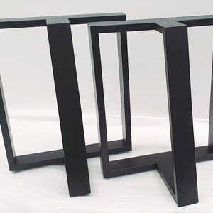 May include: Three black metal table legs with a rectangular frame and a single leg extending out at a 90-degree angle.
