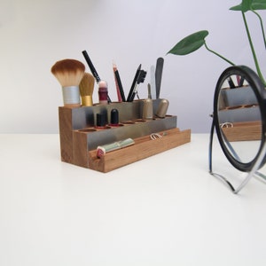 Puede incluir: Organizador de madera con compartimentos de metal para guardar pinceles de maquillaje, l&aacute;piz labial, esmalte de u&ntilde;as y otros art&iacute;culos de belleza. El organizador tiene un peque&ntilde;o estante para anillos u otros art&iacute;culos peque&ntilde;os.