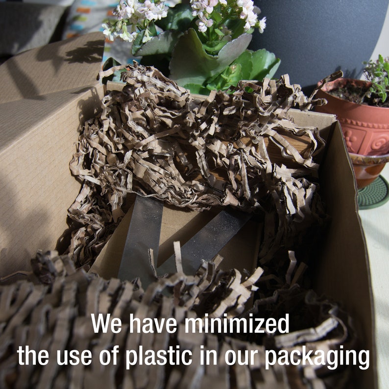 May include: A cardboard box filled with brown paper packing material. The box contains a metal object. Text on the box reads, "We have minimized the use of plastic in our packaging."