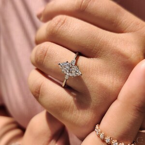 Tapered shank ring designed to enhance center marquise and pear side stones.