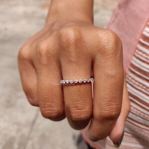 K&ouml;nnte beinhalten: Ein d&uuml;nner Silberring mit einer Reihe kleiner, klarer runder Diamanten.