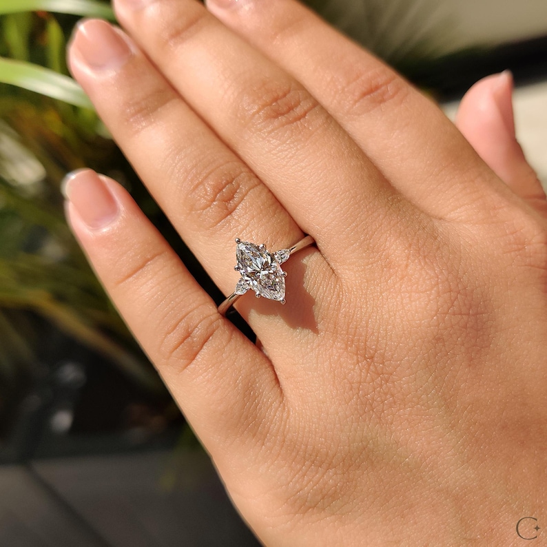 Proposal ring featuring a marquise diamond with pear side accents in a classic setting.