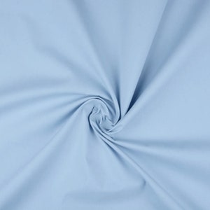 May include: A light blue fabric swatch with a smooth, soft texture. The fabric is folded and draped, showcasing its drape and flow.