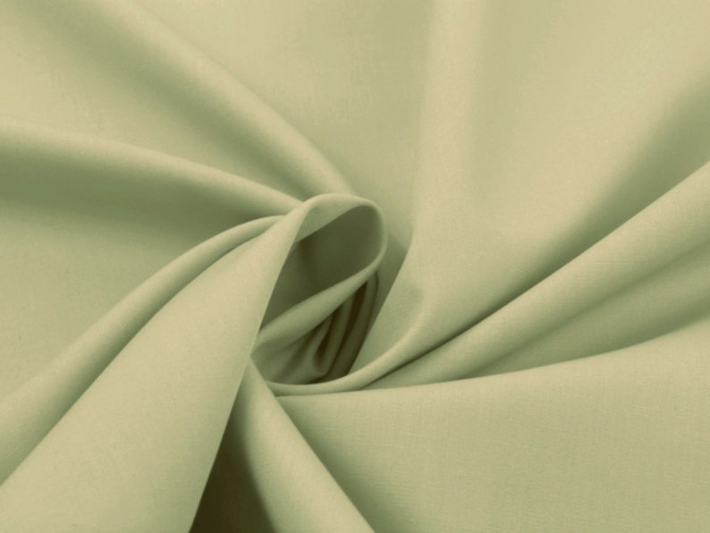 May include: A smooth, light green fabric with a soft, flowing texture. The fabric is folded and draped, creating a sense of movement and fluidity.