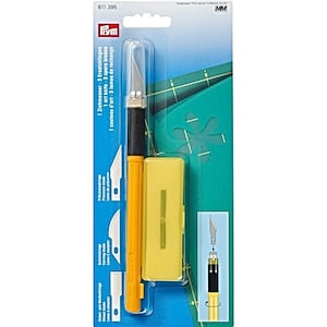 May include: A yellow and black craft knife with three replacement blades. The package includes a small yellow case for storing the blades. The text on the package reads "1 art knife - 3 spare blades".