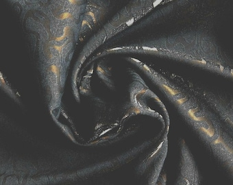 Può includere: Primo piano di un tessuto blu scuro con un motivo metallico dorato. Il tessuto è stropicciato e ha una sensazione morbida e lussuosa.
