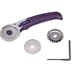 May include: A purple rotary cutter with a silver blade and a safety lock. The cutter comes with a replacement blade, a blade remover tool, and a protective cap.