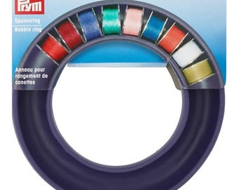 Può includere: Anello per bobine viola per riporre bobine di filo. L'anello ha 12 slot per bobine ed è etichettato "Spulenring Bobbin ring".