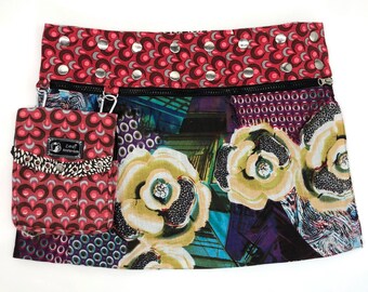 Puede incluir: Una falda colorida con estampado floral y un bolsillo con cremallera. La falda tiene una cintura con estampado rojo y negro con tachuelas plateadas. El bolsillo tiene una solapa con estampado blanco y negro con el texto "Zara Amsterdam" en ella.