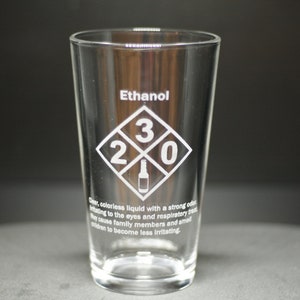 May include: A clear glass pint glass with the word "Ethanol" and a diamond-shaped symbol with the numbers "2 3 0" and a bottle icon inside. The text below the symbol reads: "Clear, colorless liquid with a strong odor irritating to the eyes and respiratory tract. May cause family members and small children to become less irritating."