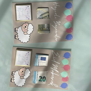 May include: Two cards with a light brown background, each with a white sheep illustration, a small gold frame with text, and a stack of euro bills. The top card has the text "Happy Holidays" in white lettering and five balloons in blue, pink, and green. The bottom card has the text "Eid Mubarak" in white lettering and four balloons in blue, pink, and green.