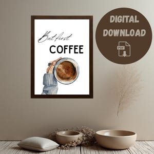 Könnte beinhalten: Gerahmter Druck mit dem Text "But first COFFEE" in Schwarz und Schrift. Das Bild zeigt eine Hand, die eine mit Kaffee gefüllte Tasse hält. Ein brauner Kreis mit "DIGITALER DOWNLOAD" und einem PDF-Symbol befindet sich rechts.