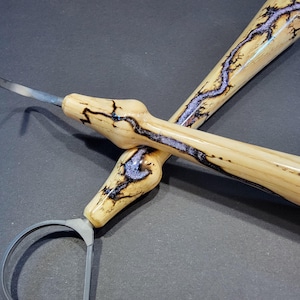 May include: A set of three ceramic mugs with a speckled, cream-colored glaze. Each mug features a different hand-painted floral design in shades of blue, green, and yellow. The mugs have a simple, rounded shape and a comfortable handle.