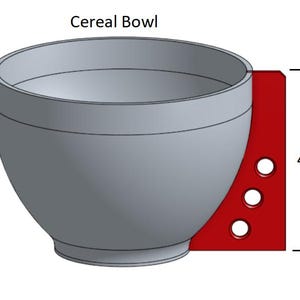 May include: A gray ceramic cereal bowl with a red side panel and three holes. The bowl is 4.75 inches tall. "Cereal Bowl" is written above the bowl.