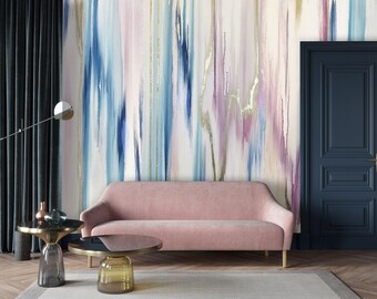 May include: A living room interior design with a pink velvet sofa, two glass coffee tables, and a dark blue door. The wall is covered with an abstract wallpaper featuring blue, pink, and gold brushstrokes.