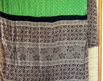 Può includere: Un tessuto verde con pois bianchi, una fascia nera e un tessuto marrone con motivi intricati in nero, rosso e bianco.