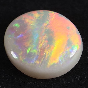 Pode incluir: Uma gema de opala branca com um arco-íris de cores, incluindo rosa, laranja, verde e azul.