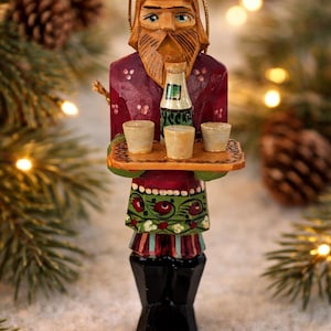 Adorno de arte popular ruso tallado a mano, hombre barbudo con vodka y vasos de chupito.