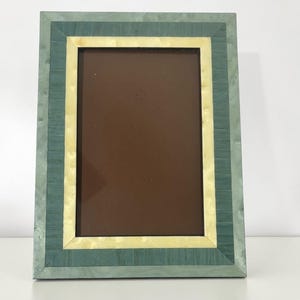 May include: A rectangular picture frame with a layered design. The frame features a teal outer border, a cream-colored middle section, and a dark brown inner area. The frame is made of wood and has a smooth finish.