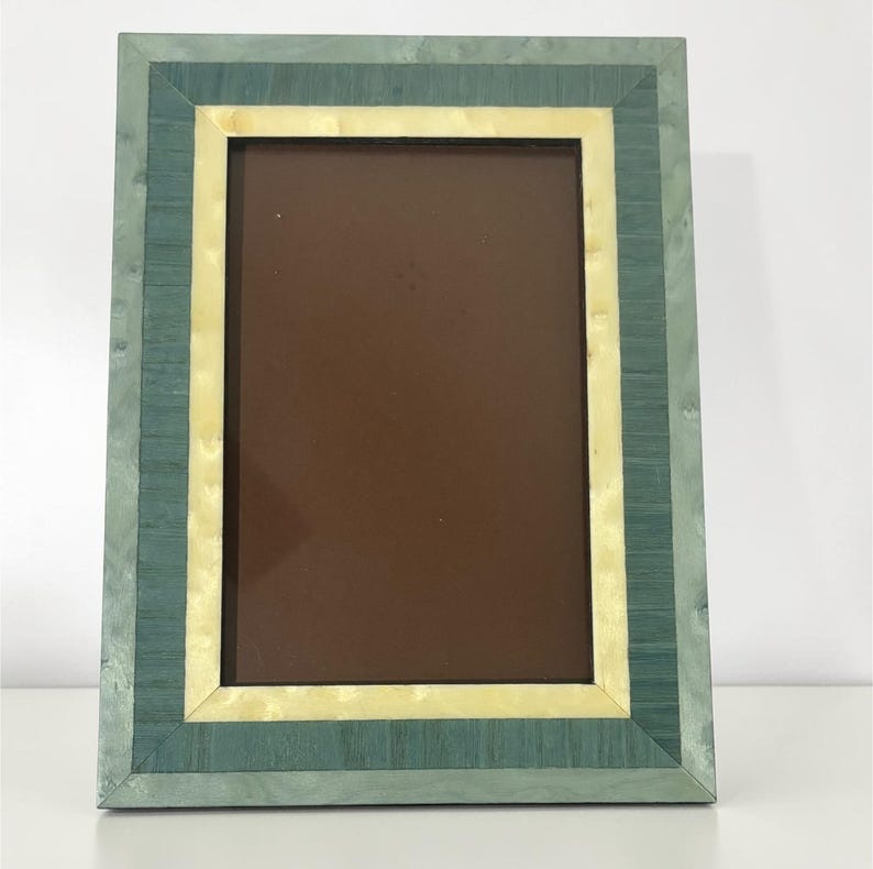 May include: A rectangular picture frame with a layered design. The frame features a teal outer border, a cream-colored middle section, and a dark brown inner area. The frame is made of wood and has a smooth finish.
