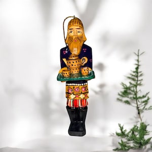 Adorno navideño de madera de arte popular ruso antiguo, tallado y pintado a mano, que representa a un hombre sosteniendo un servicio de té.