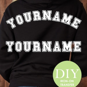 May include: Black hoodie with white iron-on lettering that says "YOURNAME" twice. The lettering is in a varsity style font. A green circle with the text "DIY IRON-ON TRANSFER" is in the bottom right corner.