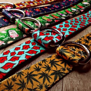May include: Five colorful dog collars with different patterns, including lips, ice cream, and marijuana leaves. Each collar has a silver metal D-ring.