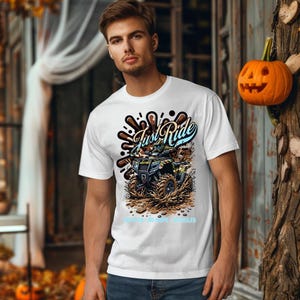 Puede incluir: Camiseta blanca con un gr&aacute;fico de un ATV conduciendo por el barro. El gr&aacute;fico incluye el texto "Just Ride" y "No Rules - No Maps - No Limits".