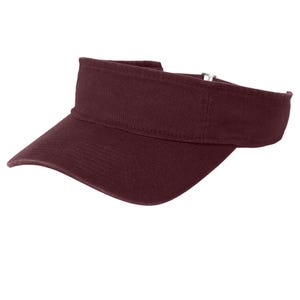 Pu&ograve; includere: Una visiera color bordeaux scuro a tinta unita con visiera curva e cinturino regolabile con fibbia in metallo sul retro. Il copricapo presenta un pannello frontale strutturato e un design aperto sulla parte superiore per la protezione.