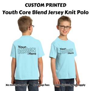 May include: A light blue youth-sized polo shirt with short sleeves. The shirt has the text "Your Design Here" printed on the front and back in black.