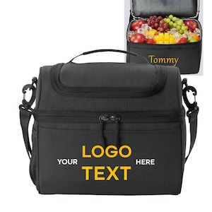 以下が含まれることがあります： 黒い断熱ランチバッグ。上部にハンドル、ショルダーストラップ、サイドメッシュポケットが付いています。バッグはジッパー付きで、前面ポケットには黄色の文字で「YOUR LOGO TEXT HERE」と書かれています。背景の開いたバッグには果物が入っています。