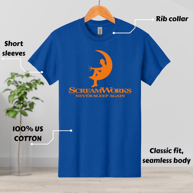 May include: A blue t-shirt with short sleeves and a rib collar. The shirt features an orange graphic of a figure in a crescent moon with the text "SCREAMWORKS NEVER SLEEP AGAIN". Made of 100% US cotton, classic fit, seamless body.