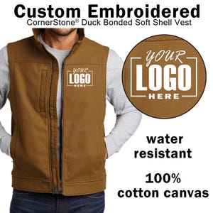 May include: A brown, water-resistant vest made of 100% cotton canvas. The vest has a zipper closure and two pockets. The vest is embroidered with the text "YOUR LOGO HERE".