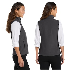May include: A charcoal grey sleeveless vest featuring a high collar, a full-length front zip, and side pockets with black zip pulls. The garment is shown from both a side profile and a back view, layered over a white long-sleeved shirt.