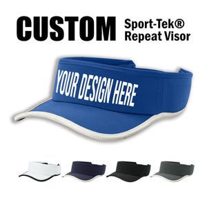 May include: A blue visor with a white brim and the text "YOUR DESIGN HERE" printed on the front. The visor is a custom product and can be personalized with a design of your choice. Sport-Tek® Repeat Visor.