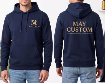 May include: A navy blue hooded sweatshirt featuring a gold logo on the front chest with the text "MC MAY CUSTOM Print, Embroidery, Design shop". The back displays the text "MAY CUSTOM Print, Embroidery, Design shop" in large gold lettering.