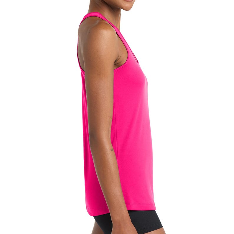 Puede incluir: Una camiseta sin mangas de color rosa intenso con dise&ntilde;o de espalda nadadora y cuello redondo. La prenda est&aacute; confeccionada en un tejido liso de color s&oacute;lido y se combina con pantalones cortos negros, ofreciendo una silueta atl&eacute;tica simple.