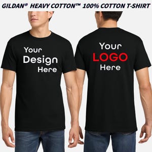 May include: Black Gildan heavy cotton t-shirts with the text "Your Design Here" on the front and "Your LOGO Here" on the back. The shirts are 100% cotton and are being modeled by a person wearing blue jeans.